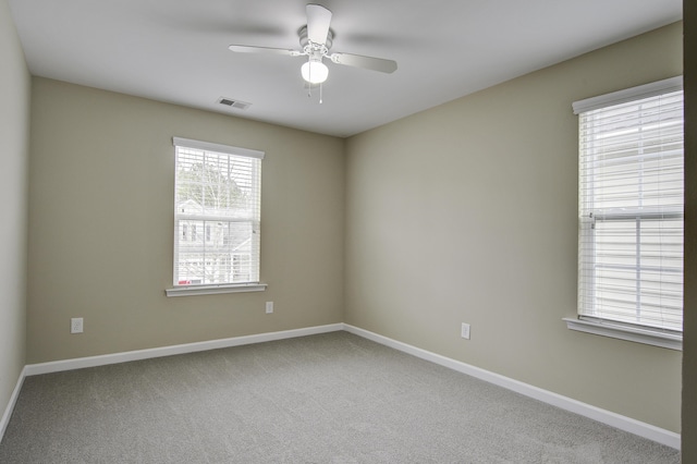 carpeted spare room featuring ceiling fan