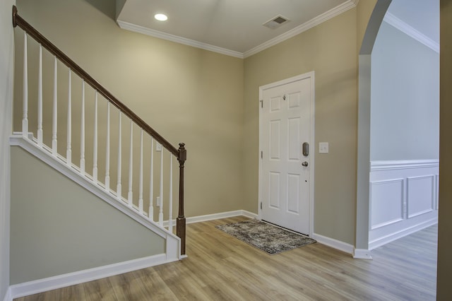 entrance foyer with crown molding and light hardwood / wood-style flooring