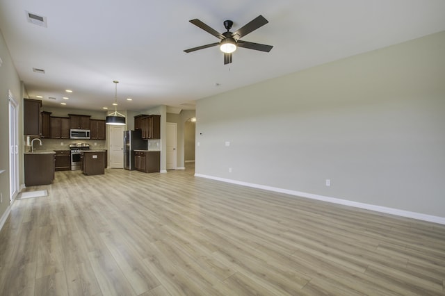 unfurnished living room with ceiling fan, light hardwood / wood-style flooring, and sink