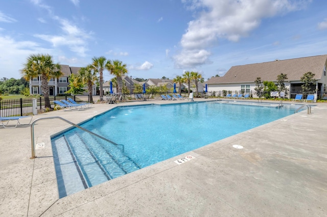community pool with fence and a patio