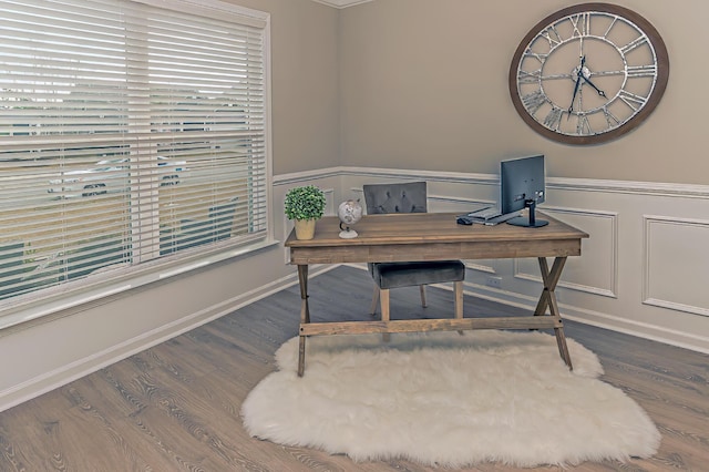 office area with wood finished floors, wainscoting, and a decorative wall