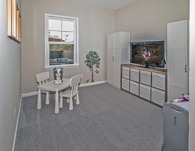 dining room featuring dark colored carpet and baseboards