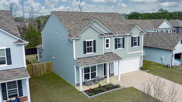 view of front of home featuring concrete driveway, a garage, covered porch, and roof with shingles