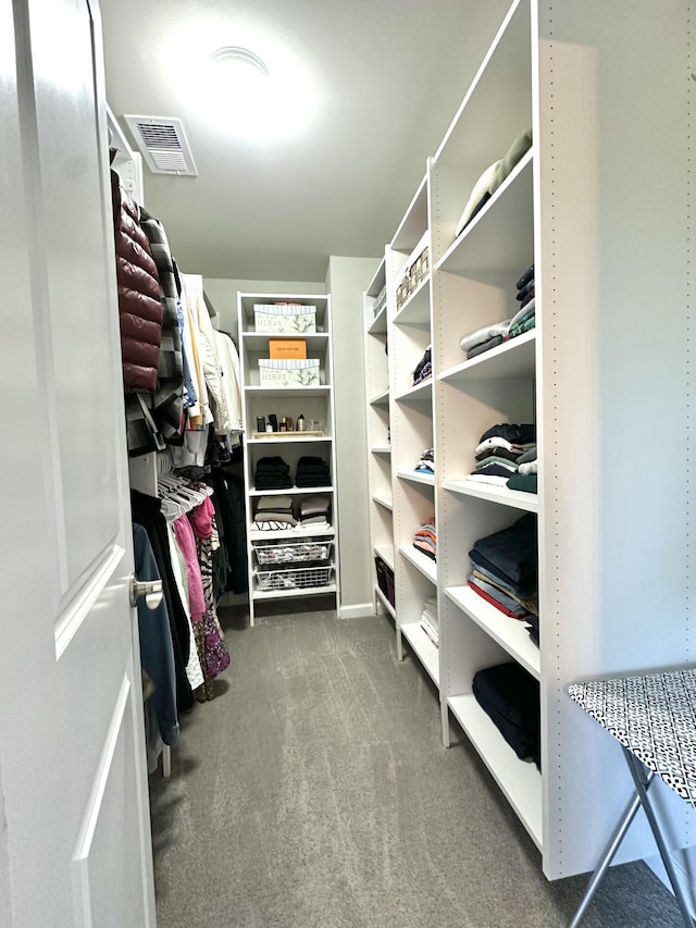 walk in closet featuring visible vents and carpet