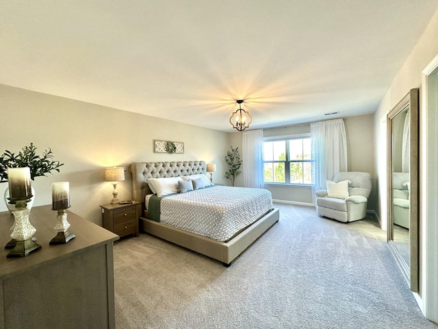 bedroom featuring light carpet and an inviting chandelier