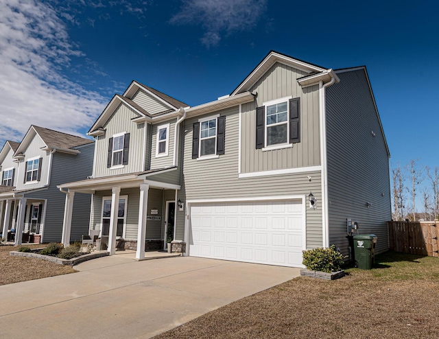 view of front of house featuring fence, a porch, concrete driveway, a garage, and board and batten siding