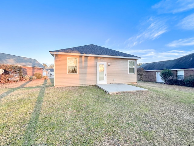 back of property with a lawn and a patio