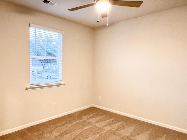 carpeted spare room with ceiling fan