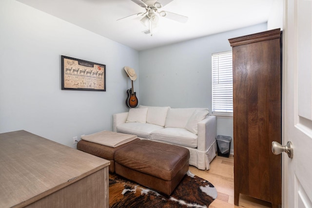 living room with ceiling fan and light hardwood / wood-style flooring