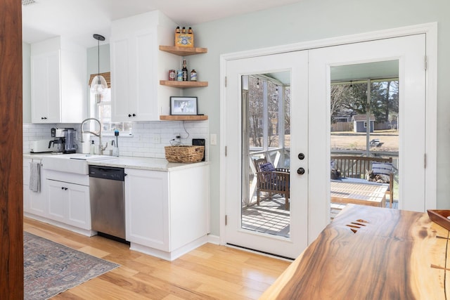 kitchen featuring dishwasher, white cabinets, hanging light fixtures, light stone counters, and french doors