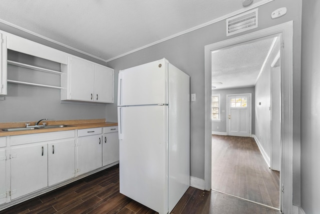 kitchen with dark hardwood / wood-style floors, white fridge, and white cabinetry