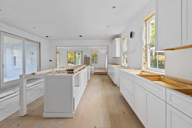 931 Kincade Dr, Mount Pleasant, SC 29464 - kitchen featuring light wood-style flooring, a center island, white cabinets, and healthy amount of natural light