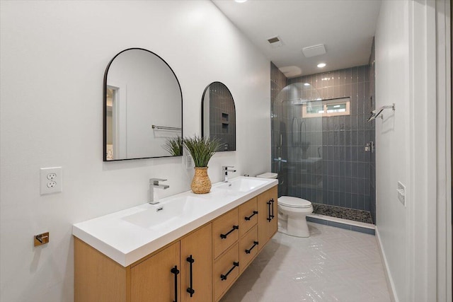 bathroom with a sink, a shower stall, toilet, and double vanity