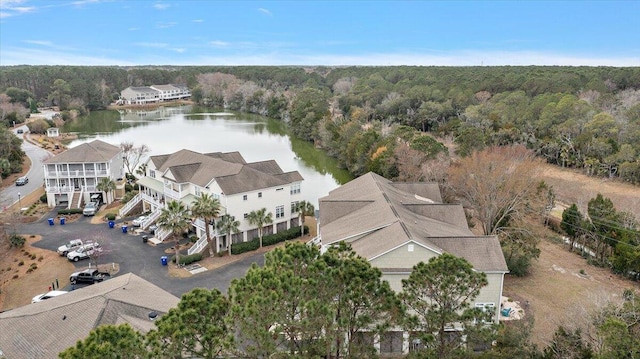 birds eye view of property featuring a water view and a wooded view