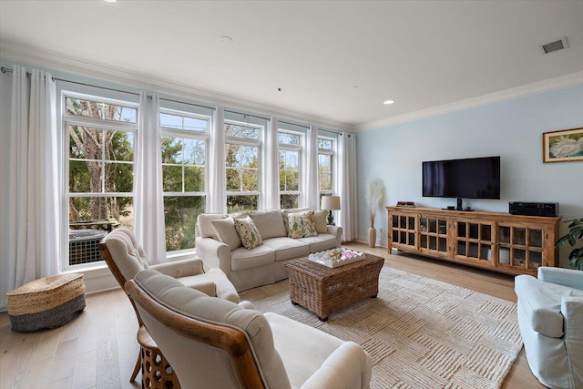 living room featuring light wood-type flooring, visible vents, crown molding, and recessed lighting