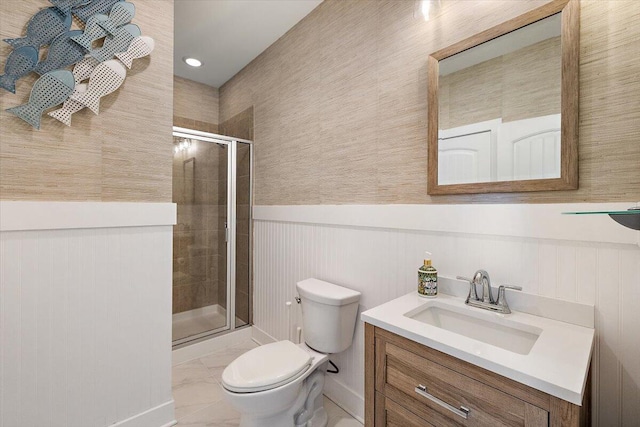 full bathroom featuring marble finish floor, toilet, a stall shower, wainscoting, and vanity