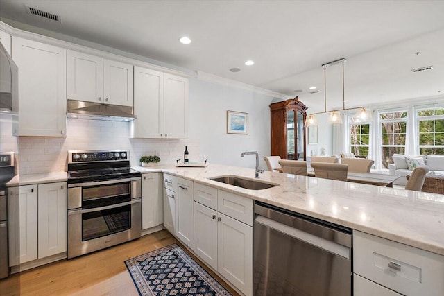 kitchen featuring stainless steel appliances, visible vents, ornamental molding, a sink, and under cabinet range hood