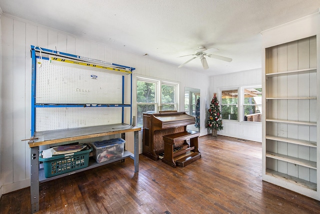 misc room featuring hardwood / wood-style floors, ceiling fan, healthy amount of natural light, and wooden walls