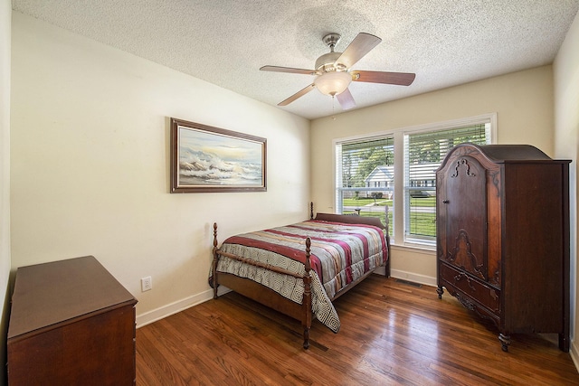 bedroom featuring baseboards, wood finished floors, a textured ceiling, and ceiling fan