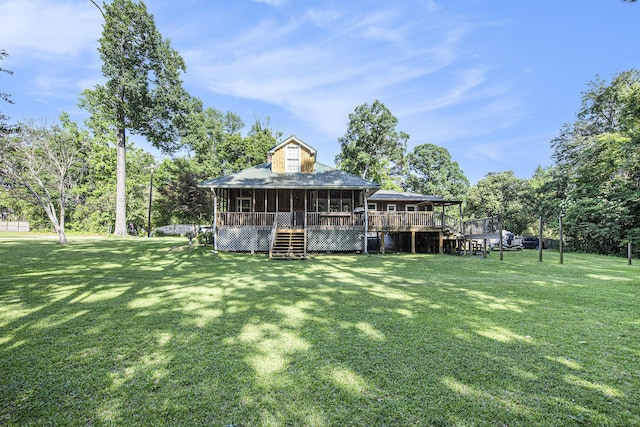 back of property featuring stairs, a sunroom, a deck, and a lawn