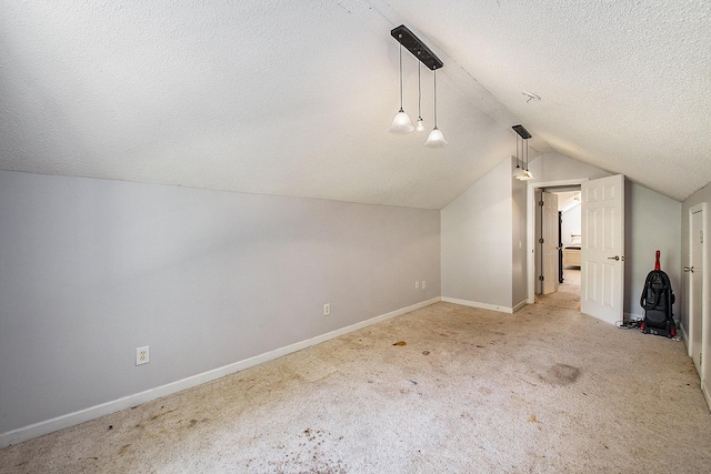 additional living space featuring lofted ceiling, carpet floors, a textured ceiling, and baseboards
