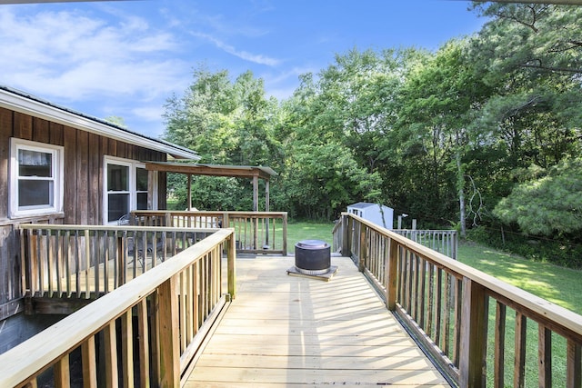 wooden deck featuring a shed and an outdoor structure