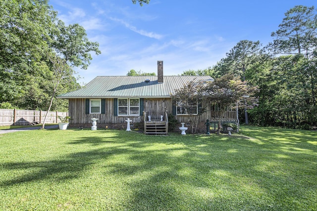 rear view of property with metal roof and a chimney
