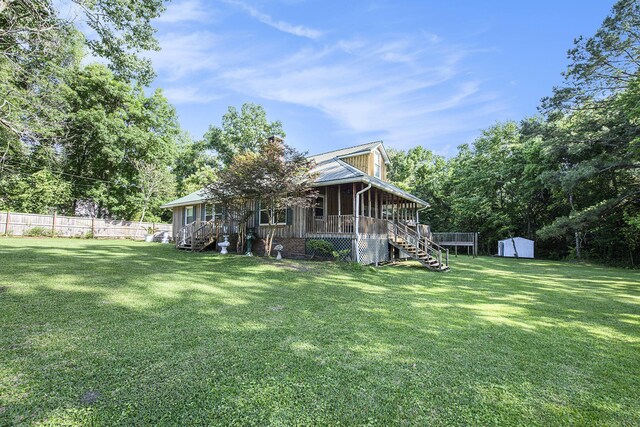 back of house featuring stairway, a storage unit, an outdoor structure, a deck, and metal roof