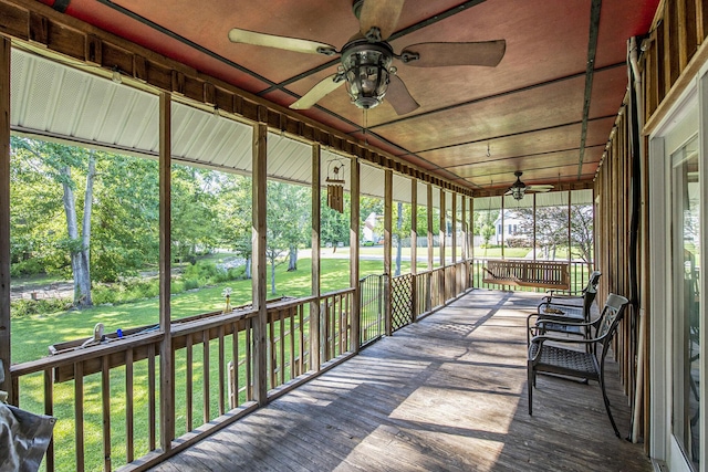 unfurnished sunroom with ceiling fan