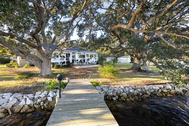 dock area with a water view and a yard