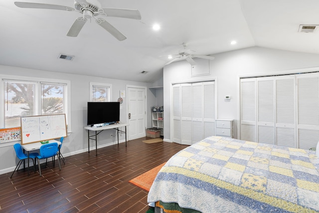 bedroom featuring lofted ceiling, wood finished floors, multiple closets, and visible vents