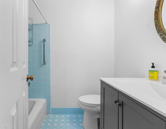 full bathroom featuring vanity, tiled shower / bath, and toilet