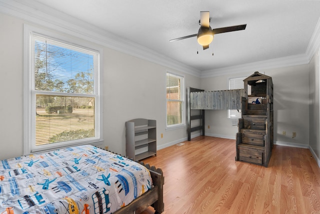 bedroom with light hardwood / wood-style flooring, ornamental molding, and ceiling fan