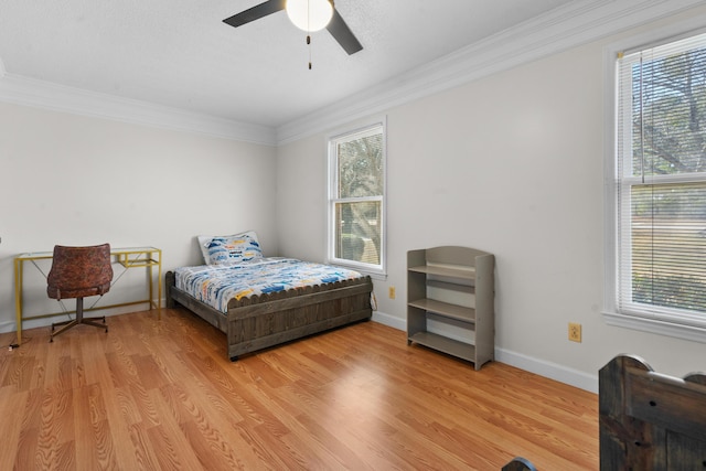 bedroom with crown molding, ceiling fan, and light hardwood / wood-style floors