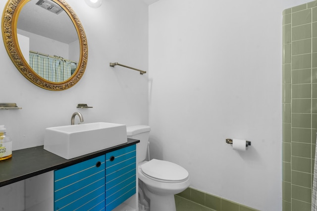 bathroom with vanity, toilet, and walk in shower