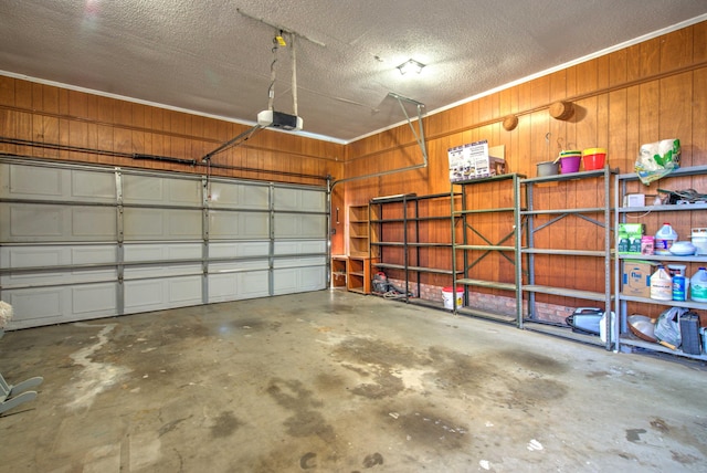 garage with a garage door opener and wood walls