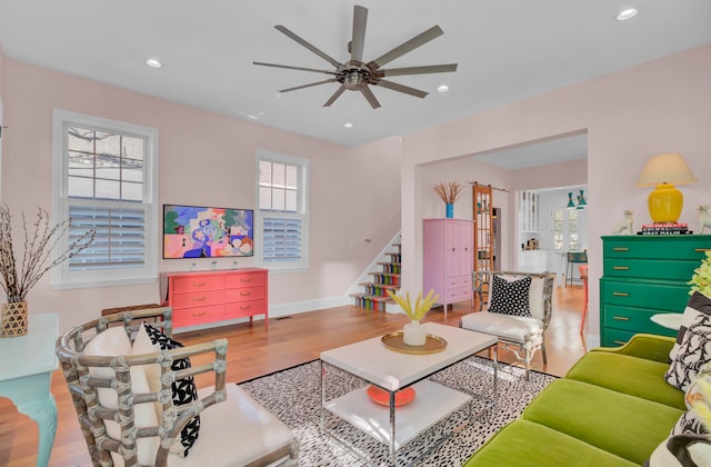 living room featuring a wealth of natural light, hardwood / wood-style flooring, and ceiling fan