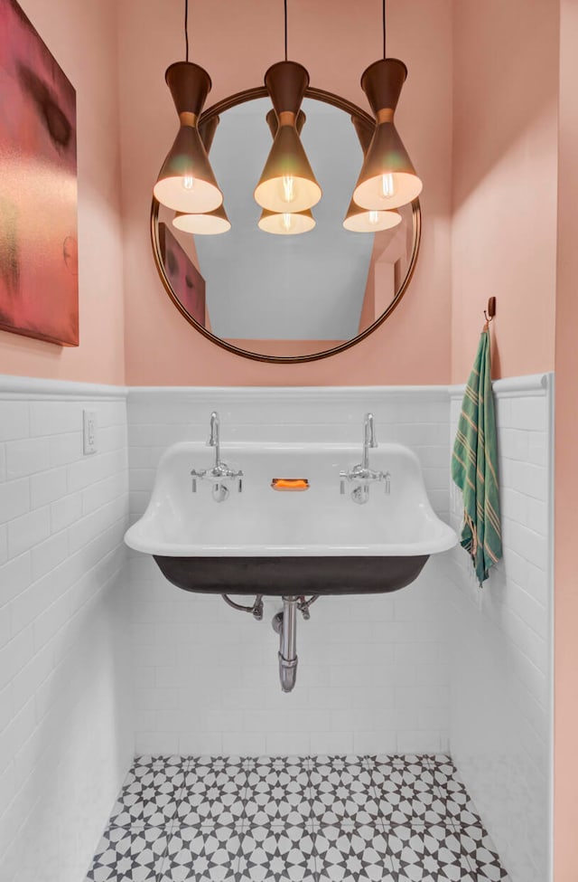 bathroom with sink, tile patterned floors, and tile walls