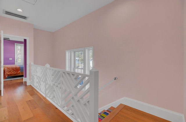 hall with wood-type flooring and a wealth of natural light