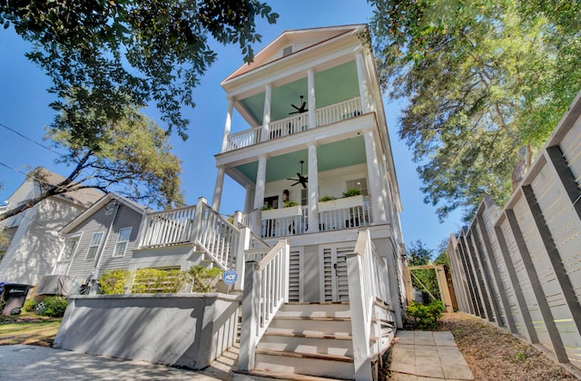 coastal home with covered porch, ceiling fan, and a balcony