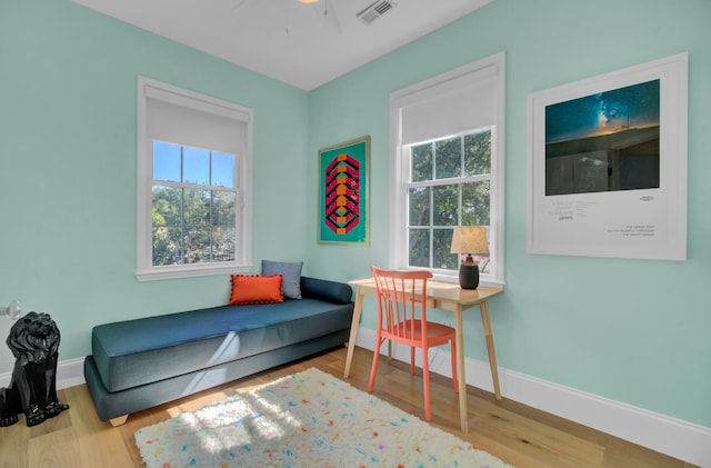 living area with ceiling fan and light hardwood / wood-style flooring