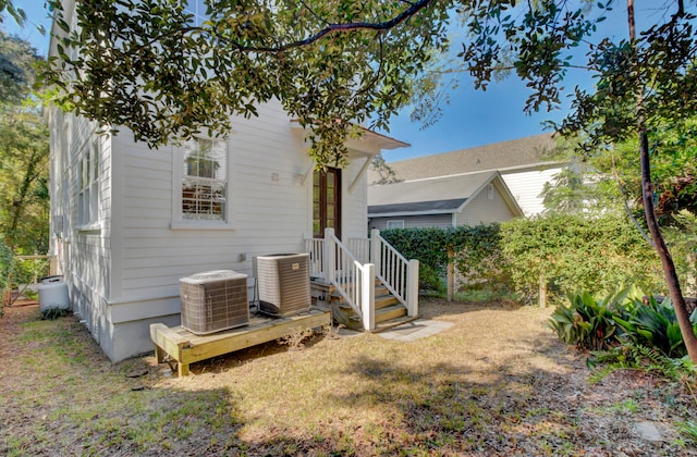 exterior space featuring cooling unit and a front lawn