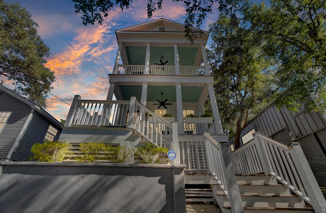 back house at dusk with a porch and ceiling fan