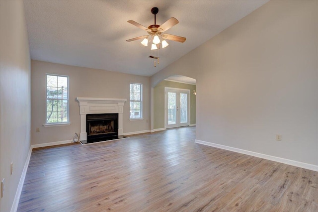 unfurnished living room with ceiling fan, plenty of natural light, and light hardwood / wood-style flooring