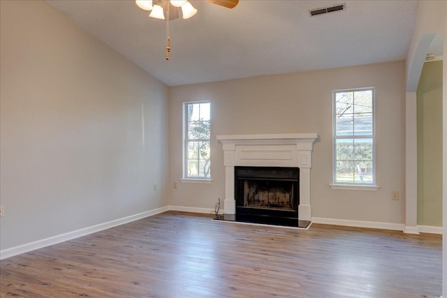 unfurnished living room with ceiling fan, light hardwood / wood-style flooring, lofted ceiling, and a healthy amount of sunlight