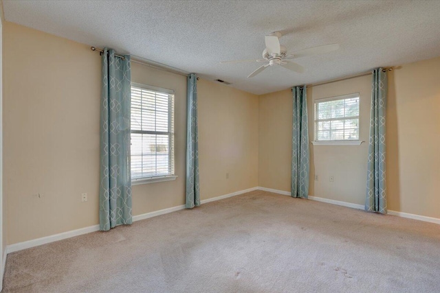 carpeted empty room with ceiling fan and a textured ceiling