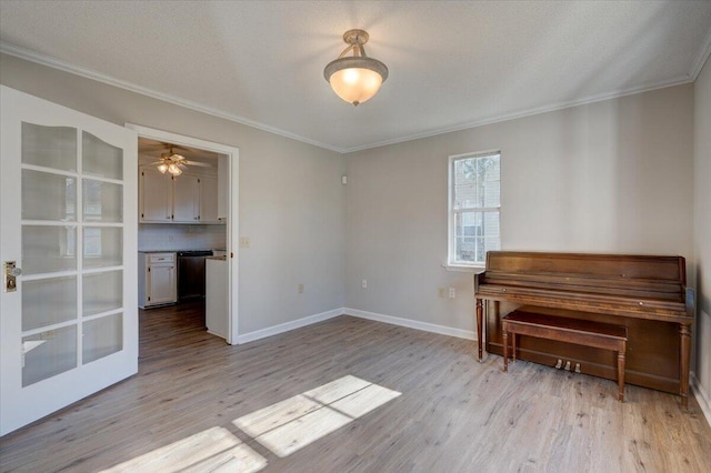 misc room with light wood-type flooring, crown molding, a textured ceiling, and ceiling fan