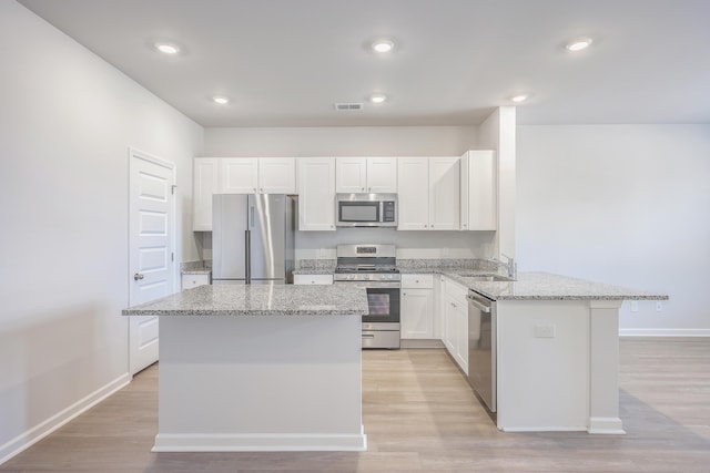 kitchen featuring light stone counters, white cabinetry, and appliances with stainless steel finishes