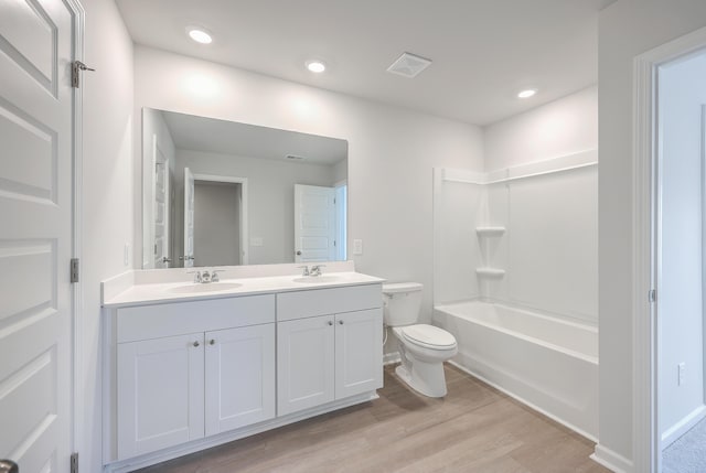 full bathroom with vanity, hardwood / wood-style floors, shower / washtub combination, and toilet