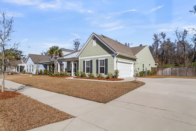 view of front facade with a garage, driveway, and fence